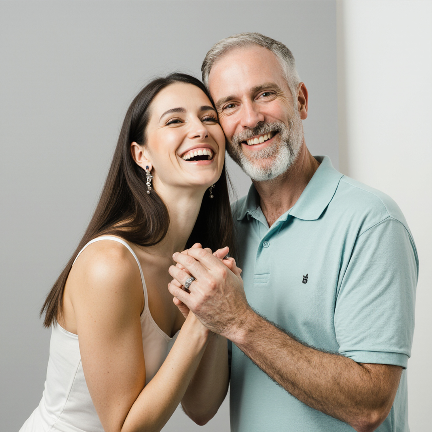 Happy couple holding hands and smiling in a studio portrait